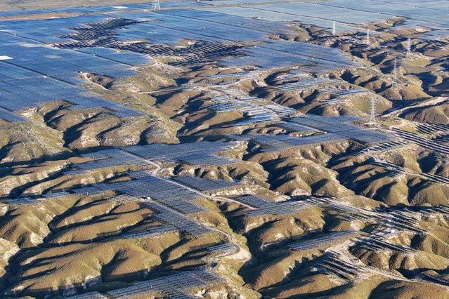 Solar panels are seen on hilltops at the Yinchuan Fourth Photovoltaic Power Station in Yinchuan, in China's northern Ningxia region on September 24, 2025. An ocean of blue solar panels ripples across the ochre dunes of Inner Mongolia's Kubuqi desert, a glittering example of China's mammoth energy transition efforts in action. Even as other countries have put the brakes on desert solar projects for economic or technical reasons, China – the world's largest emitter of greenhouse gases – is still ploughing ahead. (Photo by AFP Photo/China Stringer Network)