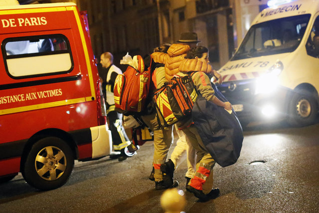 A victim is evacuated after a shooting, near the Bataclan theater in Paris, November 13, 2015. (Photo by Jerome Delay/AP Photo)
