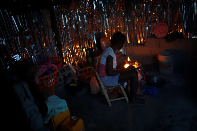 A woman cooks inside her partially rebuilt house after Hurricane Matthew hit Jeremie, Haiti, October 19, 2016. (Photo by Carlos Garcia Rawlins/Reuters)