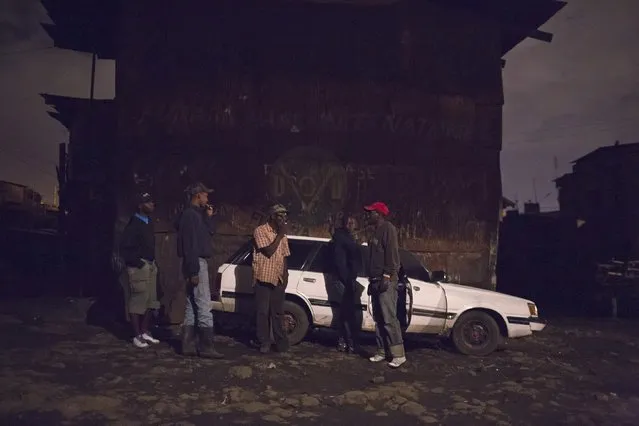 A group of men talk by a car after leaving a local bar in Majengo in Nairobi, Kenya, April 24, 2015. (Photo by Siegfried Modola/Reuters)