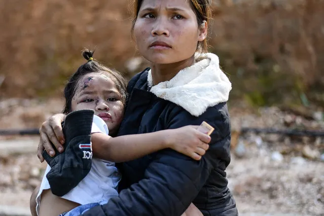 Ho Thi Ha, 28, carries her injured daughter Nguyen Tran Sa Ny after she was rescued from a landslide in Tra Leng commune in central Vietnam's Quang Nam province on October 29, 2020, in the aftermath of Typhoon Molave. (Photo by Manan Vatsyayana/AFP Photo)