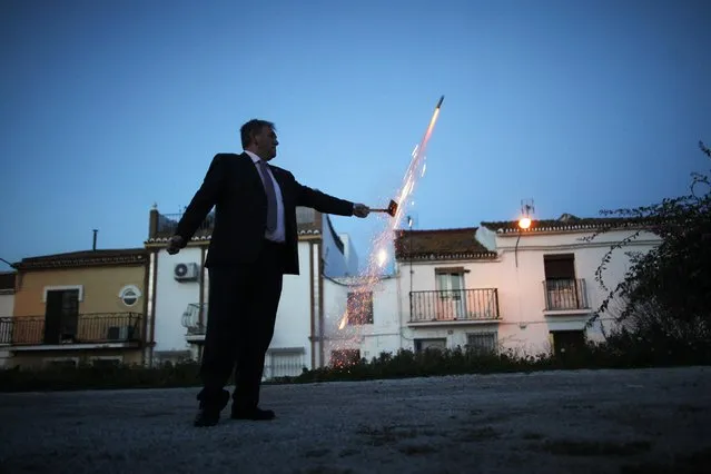 A man lights a firecracker celebrating the day of San Anton after a priest blessed animals outside of San Anton church in Churriana, near Malaga, southern Spain, January 17, 2015. (Photo by Jon Nazca/Reuters)