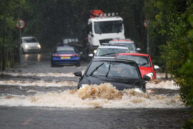 Cars make their way through flood water following torrential rain on the A760 road near to Lochwinnoch on August 2, 2020 in Lochwinnoch,Scotland. The Scottish Environment Protection Agency (SEPA) has urged Scots to prepare for potential flooding around rivers, the sea and any surface water in areas in the west of Scotland. (Photo by Jeff J. Mitchell/Getty Images)