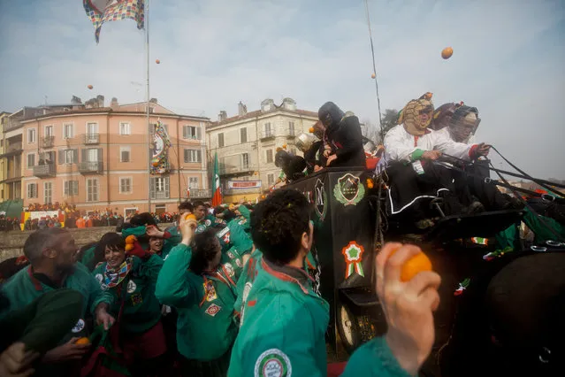 “Battle of the Oranges”. During the Battle of the Oranges alongside Tuchini del Borghetto team wearing green and red. Just before the throw. 19 of February 2012, Ivrea Italy. (Photo and caption by Lydia Pagoni/National Geographic Traveler Photo Contest)