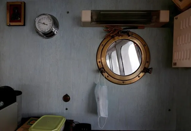 A protective face mask is seen on a porthole mirror aboard the Boulogne-sur-Mer based trawler “Nicolas Jeremy” in the North Sea, off the coast of northern France, December 8, 2020. French Fishermen net a quarter of their northeastern Atlantic catch in British waters and say their livehoods would be impacted if Brexit restricts their access to old fishing grounds. (Photo by Pascal Rossignol/Reuters)