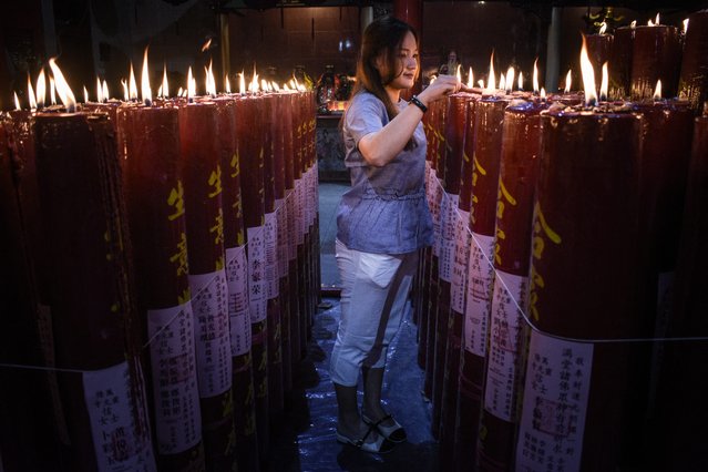 A woman lights a prayer candle at Darma Ramsi Temple to mark the Chinese Lunar New Year in Bandung, West Java, Indonesia on January 29, 2025. (Photo by Timur Matahari/AFP Photo)