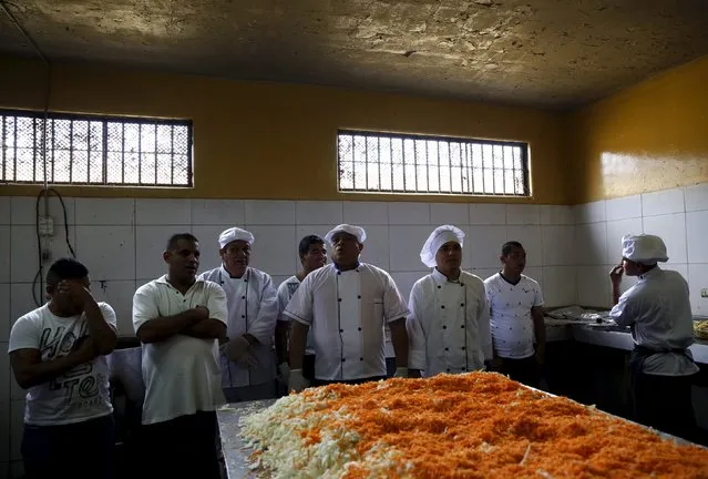 Inmates stand next to food during a Christmas event at Sarita Colonia male prison in Callao, Peru, December 18, 2015. (Photo by Mariana Bazo/Reuters)