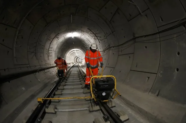 Workers lay railway track in a tunnel of the Crossrail project in Stepney, east London, Britain, November 16, 2016. Crossrail, which is Europe's largest construction project, is a railway link which will connect outlying areas to the east and west of London with tunnels under the centre of the capital. (Photo by Stefan Wermuth/Reuters)