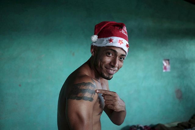 A Cuban migrant with a Cuban flag tattoo on his arm and a Santa Claus hat poses for a picture at a temporary shelter in the town of La Cruz, near the border between Costa Rica and Nicaragua, December 24, 2015. (Photo by Oswaldo Rivas/Reuters)