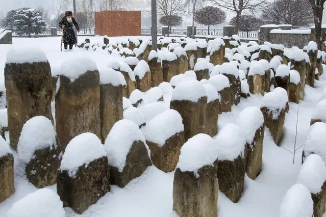 An elderly Chechen man walks to pray at a snow-covered cemetery, a memorial to the Stalin-era deportation's victims, in Grozny, Russia, Friday, March 12, 2021. Chechens and Ingush were victims of the 1944 deportations to the barren steppes of then-Soviet Central Asia. (Photo by Musa Sadulayev/AP Photo)