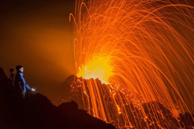 A person looks at the Piton de la Fournaise volcano in eruption Thursday, February 5, 2015, in the French Indian Ocean island of La Reunion. This is the second eruption in the past year at Piton de la Fournaise after 3-years of quiet. (Photo by Fabrice Wislez/AP Photo)