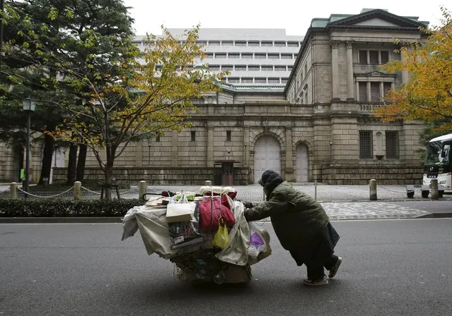 A man pushes a cart loaded with his belongings outside the Bank of Japan (BOJ) headquarters in Tokyo in this November 26, 2012 file photo. (Photo by Yuriko Nakao/Reuters)