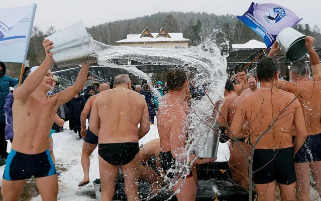 Members of a local winter swimmers club pour buckets of cold water onto each other during a celebration of Polar Bear Day at the Royev Ruchey zoo, with the air temperature at about minus 5 degrees Celsius (23 degrees Fahrenheit), in Krasnoyarsk, Russia, November 27, 2016. (Photo by Ilya Naymushin/Reuters)
