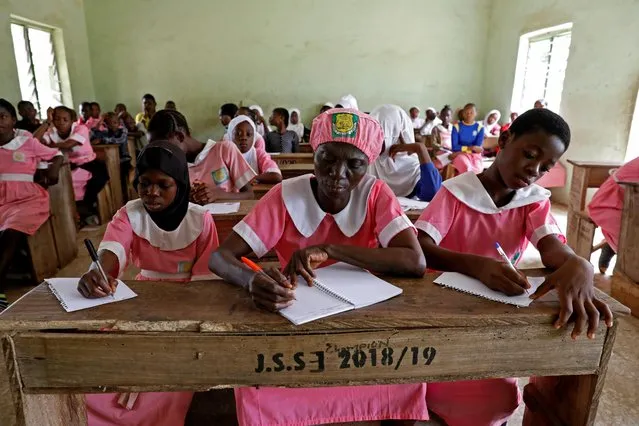 Shade Ajayi, 50, takes notes during class at Ilorin Grammar School in Ilorin, Kwara state, March 25, 2021. Ajayi had never set foot in a classroom until middle age. Now 50, she is happily learning to read and write alongside students nearly four decades younger than her. (Photo by Temilade Adelaja/Reuters)