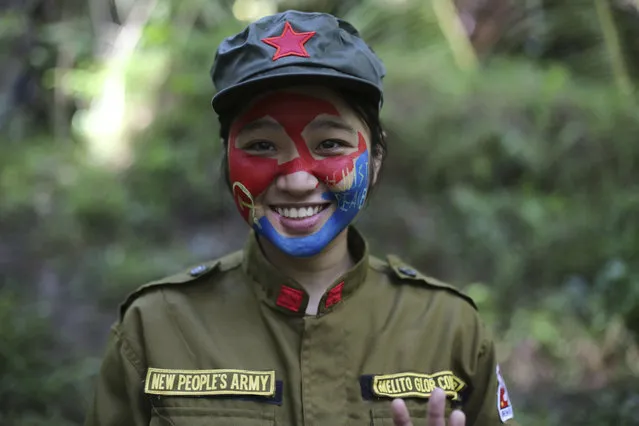 In this photo taken November 23, 2016, a 24-year-old New People's Army guerrilla, who uses the nom de guerre Comrade Katryn, smiles as she talks to reporters at a rebel encampment tucked in the harsh wilderness of the Sierra Madre mountains southeast of Manila, Philippines. Communist guerrillas warn that a peace deal with President Rodrigo Duterte's government is unlikely if he won't end the Philippines' treaty alliance with the United States and resist control by other countries. (Photo by Aaron Favila/AP Photo)