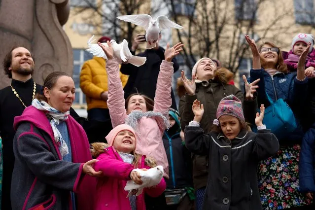 Children and their parents release birds celebrating the Annunciation on the eve of Orthodox Easter in front of the St. Tatiana Church in Moscow, Russia, Wednesday, April 7, 2021. Eastern Orthodox churches, which observe the ancient Julian calendar, usually celebrate Easter later then Western churches. (Photo by Alexander Zemlianichenko/AP Photo)