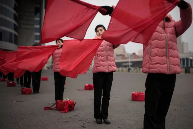 Members of a propaganda troupe wave flags as they perform as part of a 200 day campaign aimed at sustaining a new economic plan, on a street in Pyongyang on November 26, 2016. (Photo by Ed Jones/AFP Photo)