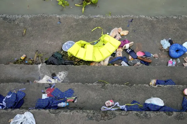 Items belonging to passengers of a capsized boat lie along the stairs of the Kalinawan port as search and rescue efforts continue in Binangonan, Rizal province, Philippines on Friday, July 28, 2023. (Photo by Aaron Favila/AP Photo)