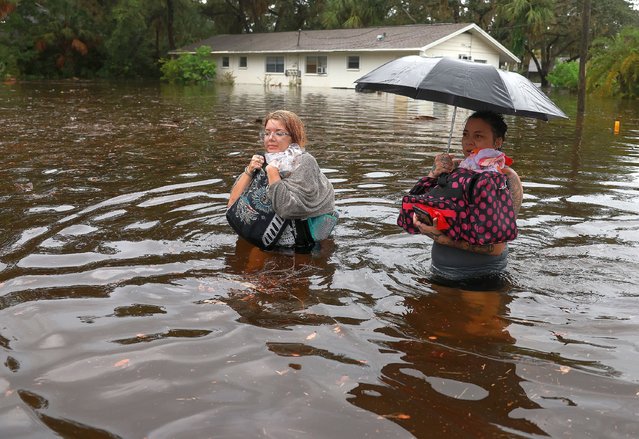 Makatla Ritchter (L) and her mother, Keiphra Line wade through flood waters after having to evacuate their home when the flood waters from Hurricane Idalia inundated it on August 30, 2023 in Tarpon Springs, Florida. Hurricane Idalia is hitting the Big Bend area of Florida. (Photo by Joe Raedle/Getty Images)