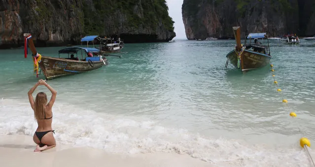 A tourist poses for a photo on Maya Bay, Phi Phi Leh island in Krabi province, Thailand, Thursday, May 31, 2018. The popular tourist destination of Maya Bay in the Andaman Sea will close to tourists for four months from Friday to give its coral reefs and sea life a chance to recover from an onslaught that began nearly two decades ago. (Photo by Sakchai Lalit/AP Photo)