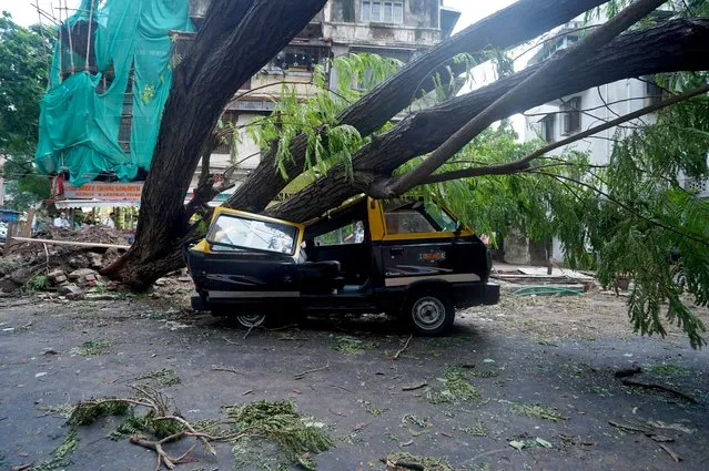 A damaged vehicle is seen under a fallen tree on a road after heavy winds caused by Cyclone Tauktae, in Mumbai, India, May 18, 2021. (Photo by Hemanshi Kamani/Reuters)