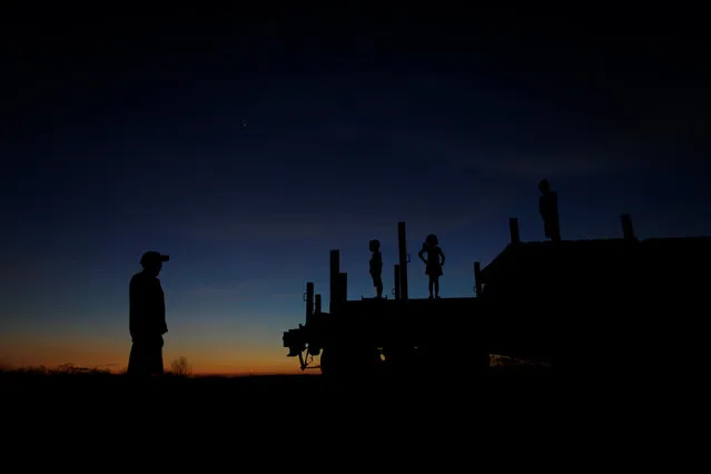 Raimundo da Silva stands nearby as his sons Daniel da Silva, Ariana da Silva and Raniel da Silva play on top of a train wagon near the city of Salgueiro, Pernambuco state, northeastern Brazil, October 26, 2016. (Photo by Ueslei Marcelino/Reuters)