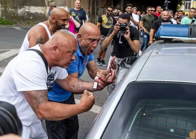 Enraged men gestures to a window of a police car during a rally to honor a Roma man Stanislav Tomas who died after police officers held him in Teplice, Czech Republic, Saturday, June 26, 2021. Tomas died after a police officer responding to a call about an altercation knelt on his neck. Police said the preliminary investigation showed no link between the police intervention and the man's death. But the angry participants condemned the police. (Photo by Ondrej Hajek/CTK via AP Photo)