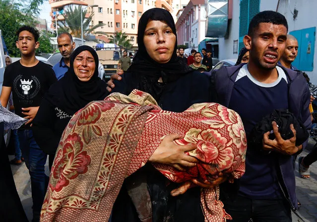 A woman holds a body of a Palestinian killed in Israeli strikes, amid the ongoing conflict between Israel and Palestinian Islamist group Hamas, in Khan Younis in the southern Gaza Strip on November 8, 2023. (Photo by Ibraheem Abu Mustafa/Reuters)