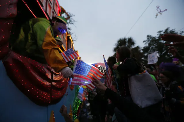 A rider throws beads as the Krewe of Endymion hands American flags to parade-goers as the Mardi Gras parade rolls through New Orleans, Saturday, February 6, 2016. (Photo by Gerald Herbert/AP Photo)