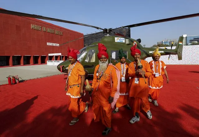 Performers walk past a helicopter parked at the exhibition centre of the “Make In India” week in Mumbai, India, February 13, 2016. (Photo by Danish Siddiqui/Reuters)