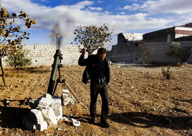 A “Free Syrian Army” fighter, part of the Rayat Al Sham Al-Islami Brigade, reacts as he fires a mortar shell towards forces loyal to Syria's President Bashar al-Assad at the 80th Brigade base in Aleppo, on December 8, 2013. (Photo by Molhem Barakat/Reuters)