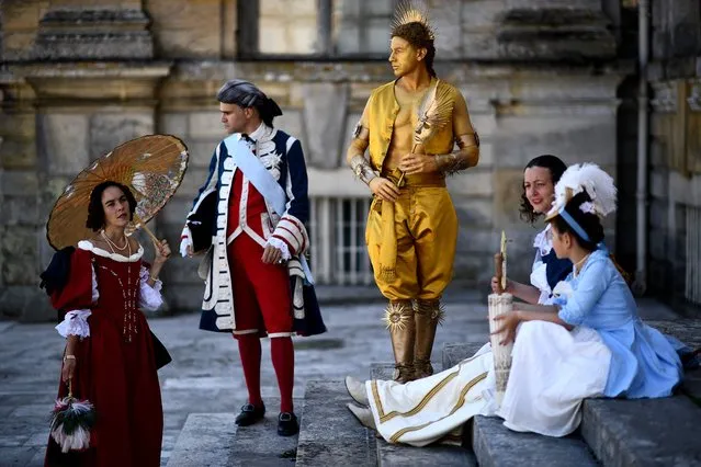 People dressed in 17th-century costumes take part in “La grande journee des costumés”, an historical event gathering hundreds at the Vaux-le-Vicomte castle (background) in Maincy, some 50 kms south-east of Paris on June 25, 2023. (Photo by Christophe Archambault/AFP Photo)