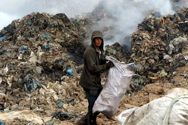 A garbage collector looks for recyclable waste at a dump in Erbil, in Iraq's northern autonomous Kurdistan region, February 21, 2016. (Photo by Azad Lashkari/Reuters)
