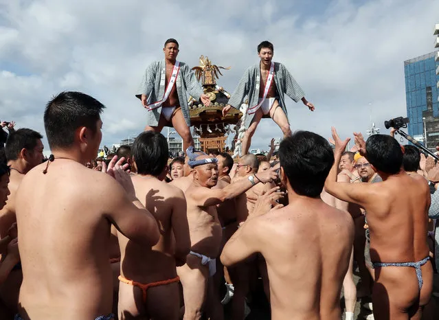 New adults stand on a portable shrine carried along the seashore during a purification ceremony at Katase-Enoshima beach on January 15, 2017 in Fujisawa, Japan. The annual festival with portable shrines celebrates the coming-of-age for young people. (Photo by Aflo/Barcroft Images)