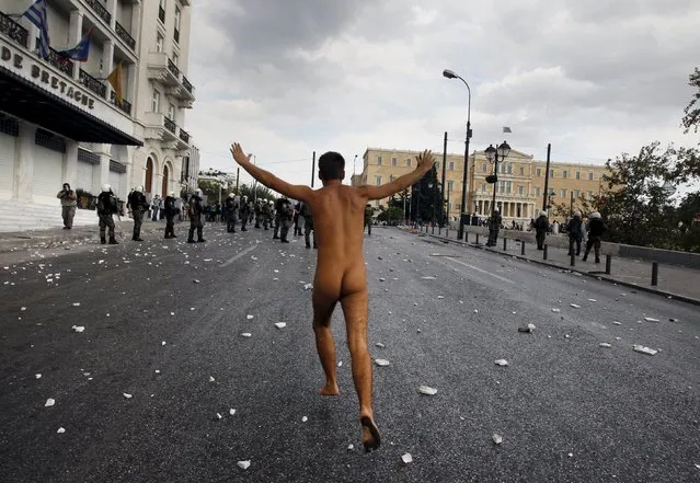 A naked protester runs past the parliament in Syntagma Square in Athens during a violent protest against the visit of Germany's Chancellor Angela Merkel, in this October 9, 2012 file photo. (Photo by John Kolesidis/Reuters)