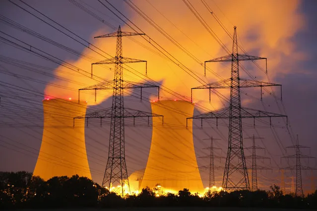 Steam rises from the Grafenrheinfeld nuclear power plant as electricity pylons stand before it at night on June 11, 2015 near Grafenrheinfeld, Germany. (Photo by Sean Gallup/Getty Images)