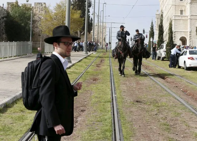 An ultra-Orthodox Jewish onlooker stands near Israeli mounted police near the scene where Israeli police said two Palestinian assailants carried out a drive-by shooting on cars before being shot dead by police opposite the Notre Dame Center just outside Jerusalem's Old City March 9, 2016. (Photo by Ammar Awad/Reuters)