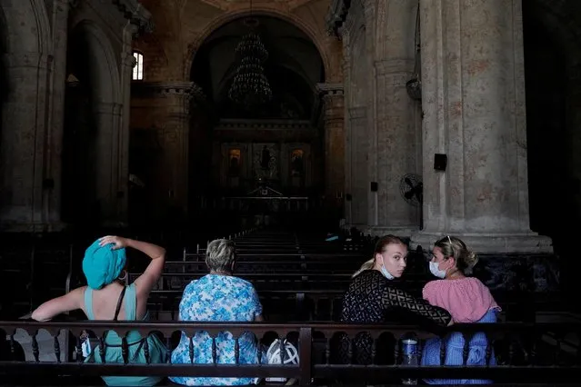 Tourists from Russia sit inside the Havana's Cathedral amidst the coronavirus disease (COVID-19) outbreak, Cuba on July 19, 2021. (Photo by Alexandre Meneghini/Reuters)