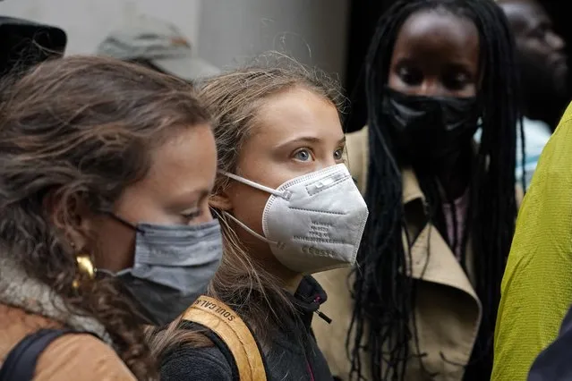 Climate activists Greta Thunberg, center, and Vanessa Nakate, right, demonstrate in front of the Standard and Chartered Bank during a climate protest in London, England, Friday, October 29, 2021. People were protesting in London ahead of the 26th U.N. Climate Change Conference (COP26), which starts Sunday in Glasgow, Scotland. (Photo by Alberto Pezzali/AP Photo)