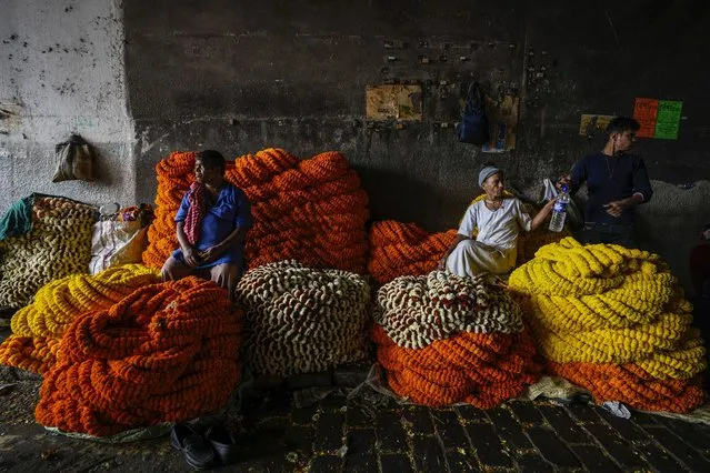 Vendors with marigold garlands await customers at a wholesale flower market in Kolkata, India, Thursday, February 22, 2024. (Photo by Bikas Das/AP Photo)