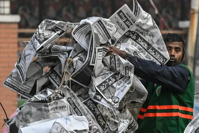 A civic worker dumps election posters in a van after tearing them down on a street corner a day after the Awami League party led by prime minister Sheikh Hasina won Bangladesh's parliamentary elections, in Dhaka on January 8, 2024. (Photo by Indranil Mukherjee/AFP Photo)