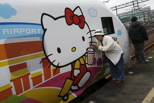 Fans pose next to Hello Kitty-themed Taroko Express train in Taipei, Taiwan March 21, 2016. (Photo by Tyrone Siu/Reuters)