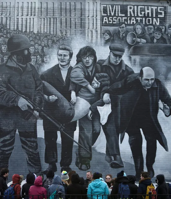 Tourists stand in front of a mural depicting the Bloody Sunday events, in Londonderry, Northern Ireland March 14, 2019. (Photo by Clodagh Kilcoyne/Reuters)