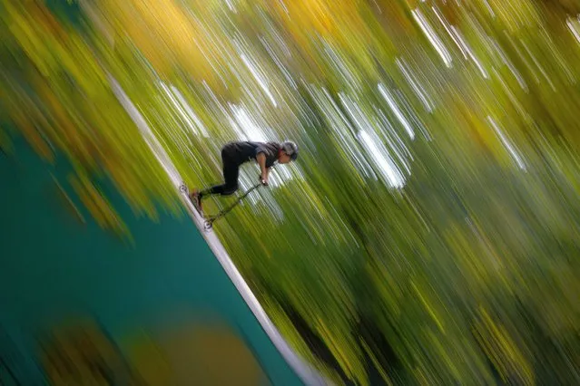 A child shows off acrobatic skills on a scooter in a park in Bucharest, Romania, Tuesday, October 19, 2021. (Photo by Vadim Ghirda/AP Photo)