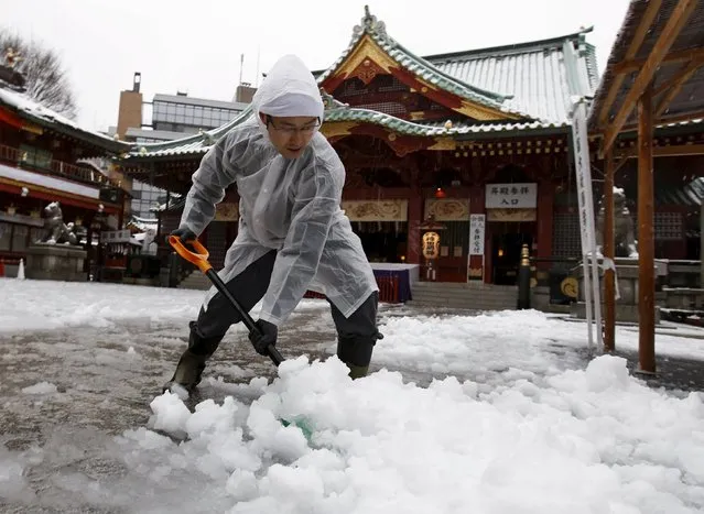 A man clears snow from a walkway at Kanda Miyojin Shrine in Tokyo, Japan January 18, 2016. (Photo by Toru Hanai/Reuters)