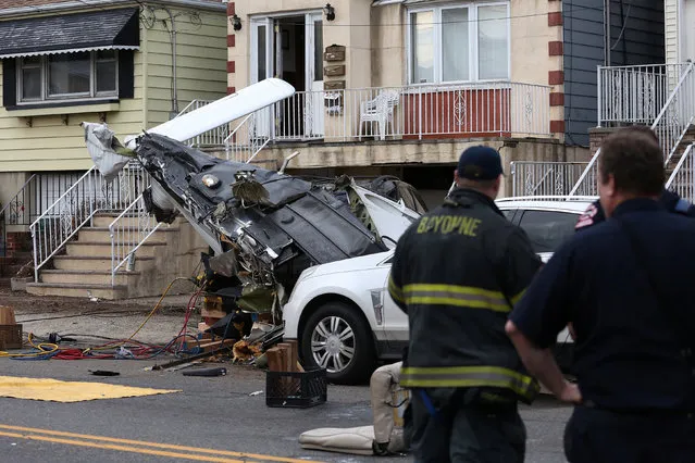 Officials survey the scene where a small plane crash landed on a residential street in Bayonne, New Jersey, U.S. February 19, 2017. (Photo by Ashlee Espinal/Reuters)