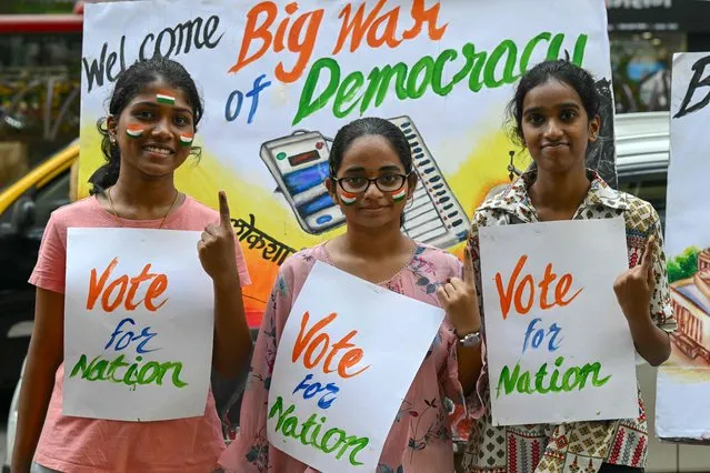 Art school students pose with posters illustrating the upcoming India's parliamentary elections, in Mumbai on March 16, 2024. (Photo by Indranil Mukherjee/AFP Photo)