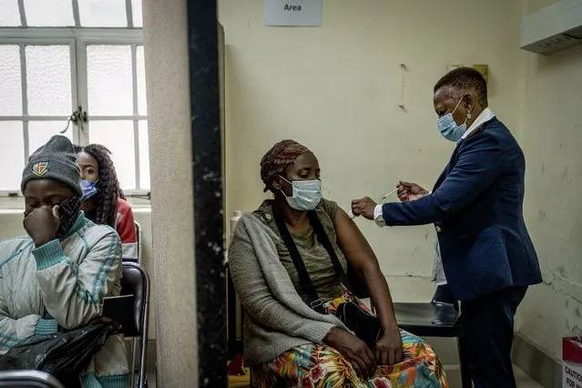 A woman is vaccinated against COVID-19 at the Hillbrow Clinic in Johannesburg, South Africa, Monday December 6, 2021. South African doctors say the rapid increase in COVID-19 cases attributed to the new omicron variant is resulting in mostly mild symptoms. (Photo by Shiraaz Mohamed/AP Photo)