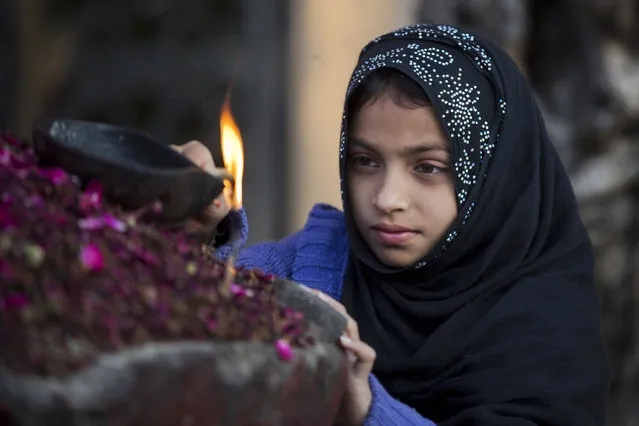 A Pakistani girl lights an oil lamp to get her wishes fulfilled at a local shrine in suburbs of Islamabad, Pakistan, Monday, March 7, 2016. (Photo by B.K. Bangash/AP Photo)