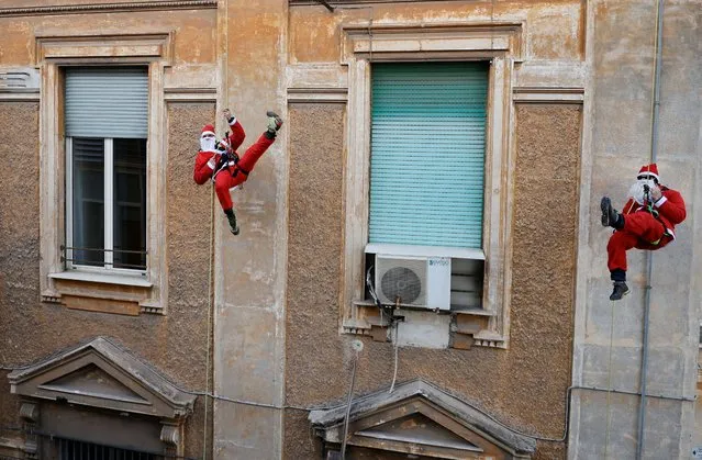 Alpine Rescue Team members dressed as Santa Claus rappel down the Policlinico Umberto I Hospital to greet children hospitalised in the paediatric ward, in Rome, Italy, December 23, 2021. (Photo by Yara Nardi/Reuters)